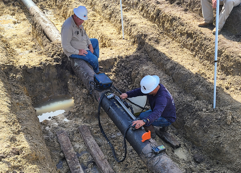 Workers inspecting pipeline in trench